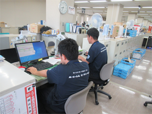 写真：大会PR用ポロシャツを着用して業務中2