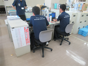 写真：大会PR用ポロシャツを着用して業務中1