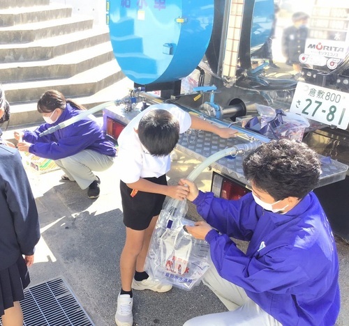 写真:給水車から給水パックに注水する様子