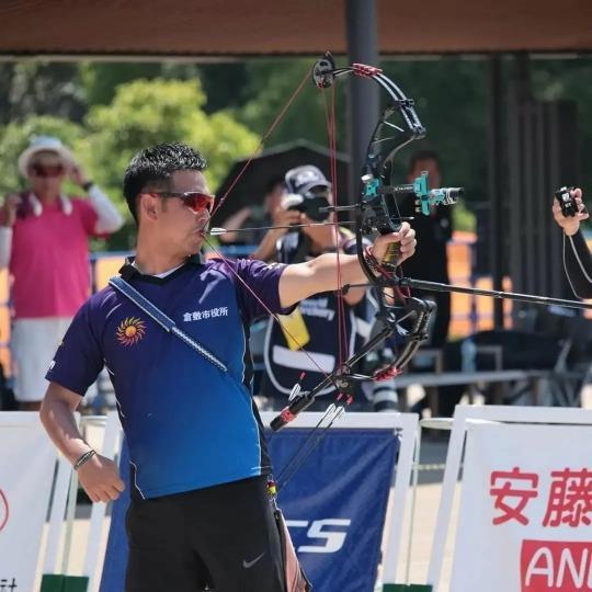 写真：口を使って弦を引く大江選手