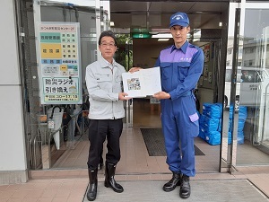 写真：かつらぎ町の担当者に物資贈呈する隊員