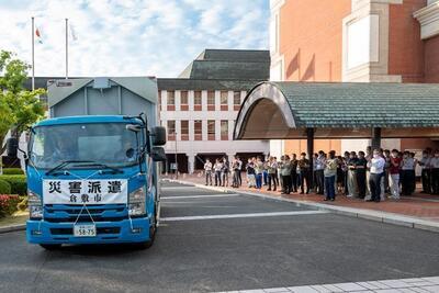 写真：庁舎前に止まるトラックと集まった人