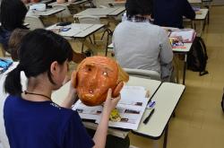 写真：素隠居の面を眺める学生